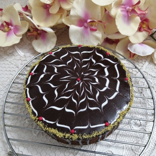 کیک کاکائویی گرد با روکش گاناش و دیزاین پودر پسته و شکلات