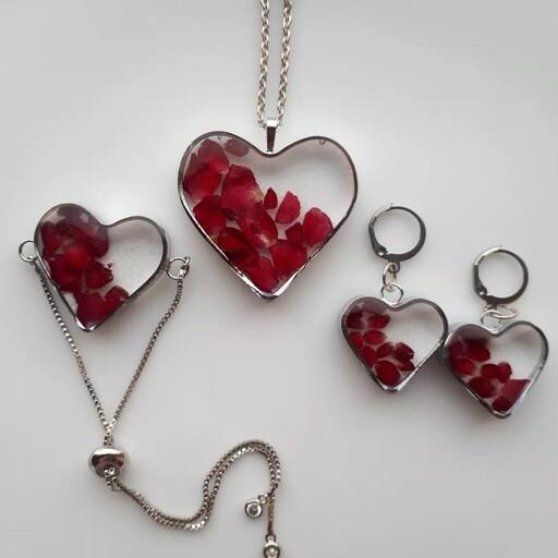 گردنبند و دستبند و گوشواره سِت رزینی قلب کار شده با گل سرخ طبیعی فریم و اتصالات استیل رنگ ثابت