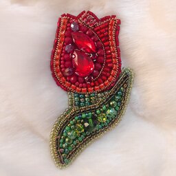 سنجاق سینه جواهر دوزی طرح(گل)و پشت تماماً چرم و به رنگ قرمز/سبز می‌باشد.