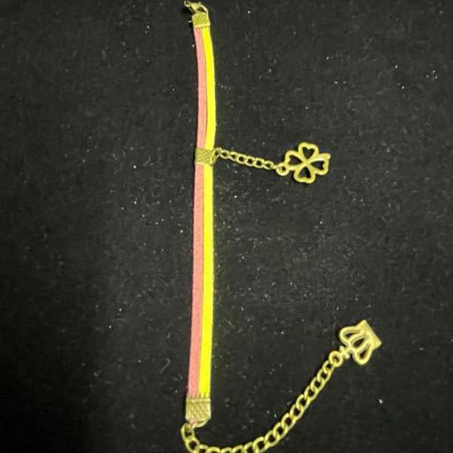 دستبند تریشه چرمی مدل ساده دو رنگ زرد و صورتی کم رنگ با زنجیر و خرج کار برنزی مدل گل و تاج 