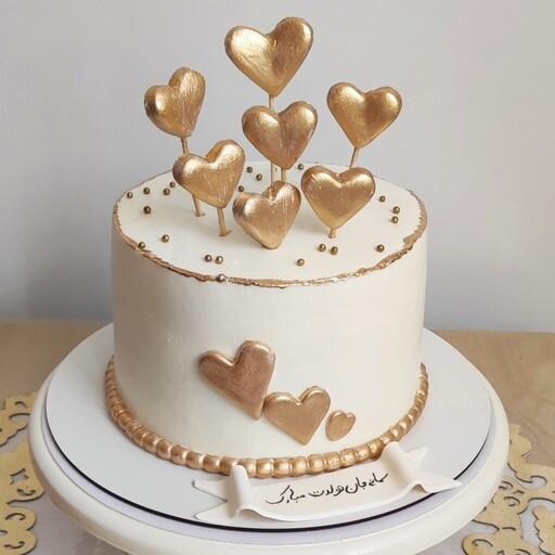 کیک تولد دخترانه قلبی طلایی با فیلینگ موزگردو و سس شکلات و شکلات چیپسی 