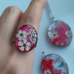 انگشتر زنانه استیل نقره ایی با شکوفه طبیعی سفید و زمینه زرشکی رزینی