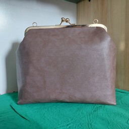 کیف چرمی دهنه فلزی 23 س م ،با یک جیب کوچک داخل کیف و دسته ترکیب زنجیر و چرم