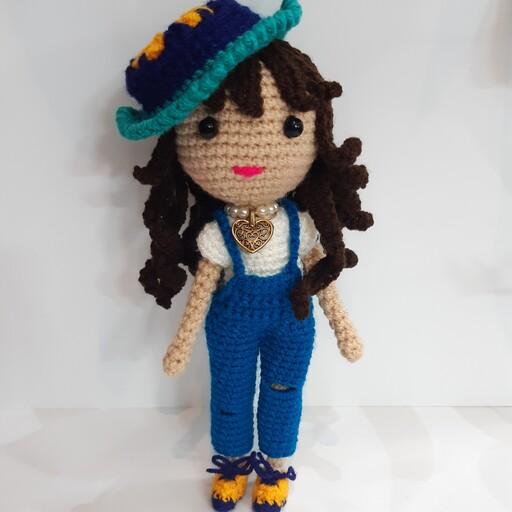 عروسک دختر مفصل دار با کلاه و شلوار پیشبند دار و گردن بند زیبا 
