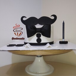 کیک خانگی طرح سبیل مردانه  زمینه سفید به وزن یک کیلو با فیلینگ موز و گردو و شکلات چیپسی 