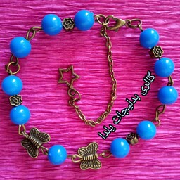 بدلیجات دستبند مهره ای تزئین شده با آویز ستاره وخرج کار برنز پروانه وگلهای ریز برنز بین مهره ها و مروارید های آبی رنگ
