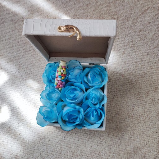 باکس گل رز آبی مصنوعی صندوقی چرمی مربع سفید با بطری اسمارتیز   جعبه کادو روز دختر هدیه