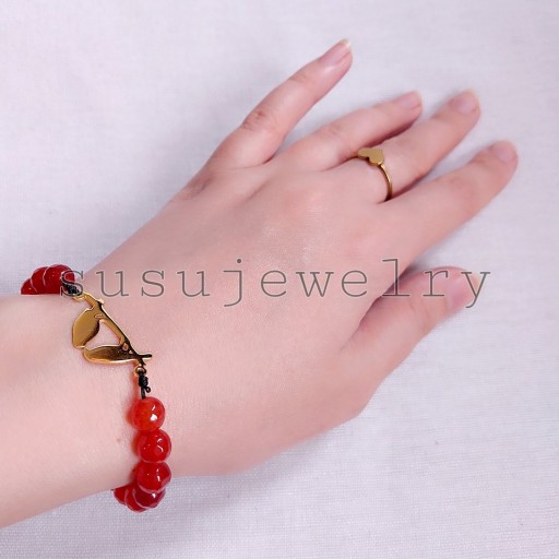 دستبند سنگ عقیق قرمز  زنانه با پلاک استیل دو پرنده عاشق طلایی  بافت قابل تنظیم